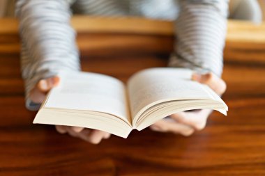 Evde bir kitap tutan el