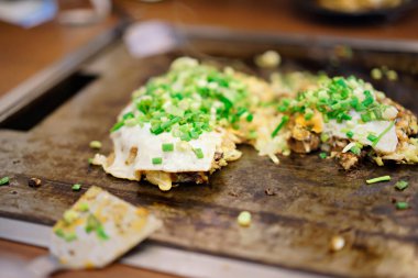 Okonomiyaki restoranda teppanyaki tavada. Japonya gıda kavramı