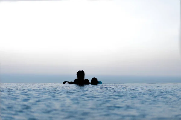 Silhouette von Papa und Kindern im Schwimmbad zum Entspannen. — Stockfoto
