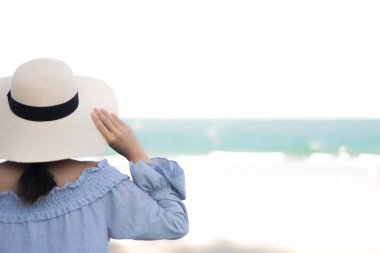 Seyahat için denizde sahilde saman şapkası olan kadın