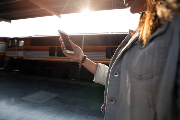 Азиатка использует смартфон для поездок на поезде — стоковое фото