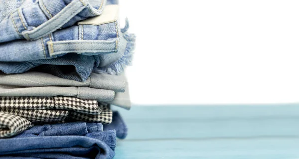 Stacked clothes and pants on isolated white — Stock Photo, Image