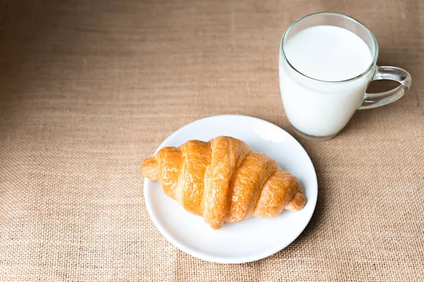 Круассаны и молоко на столе . — стоковое фото