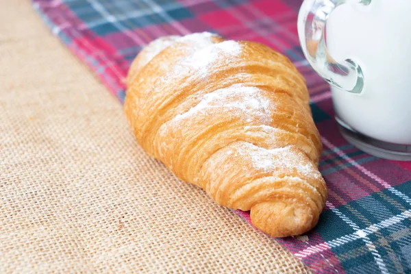 Croissants mit Zuckerguss und Milch auf dem Tisch. — Stockfoto