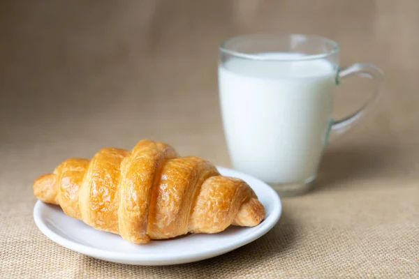 Croissant és tej az asztalon. — Stock Fotó