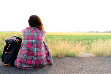 Yol kenarında oturan seyahat ve sırt çantası. Seyahat sorunu kavramı.