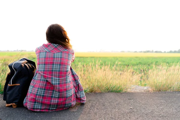 Yol kenarında oturan seyahat ve sırt çantası. Seyahat sorunu kavramı.