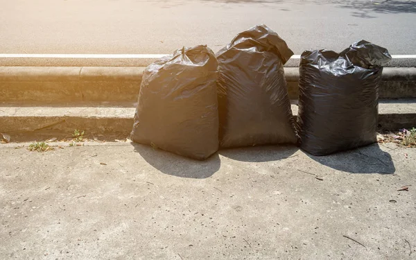 Fekete műanyag táska a szemét a nyilvános parkban — Stock Fotó