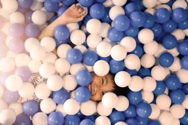 Küçük çocuk oyun alanında top havuzu oynuyor