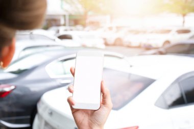 Otoparkta beyaz ekranlı el ele tutuşan akıllı telefon