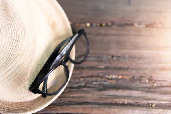 Óculos e chapéu sobre fundo de madeira — Fotografia de Stock