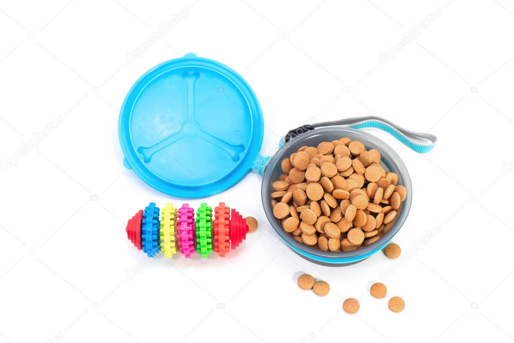 Pet accessories concept.  Pet bowl with dry food and toy 