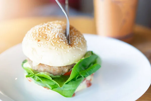 Hamburger v bílé keramické misce v restauraci — Stock fotografie