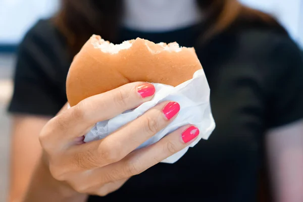 Mulher mão segurando hambúrguer para fast food — Fotografia de Stock