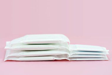 Sıhhi peçete yastık pembe bir arka plan üzerinde yığılmış.