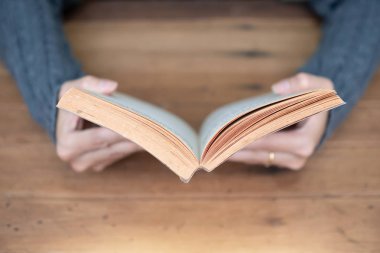 Evde bir kitap tutan el