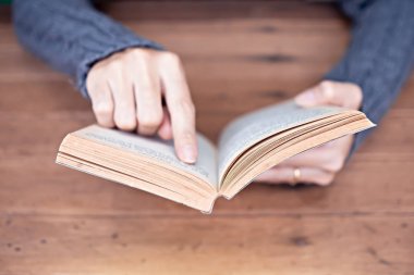 Evde bir kitap tutan el