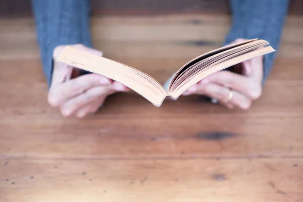 Ruka držící knihu doma — Stock fotografie