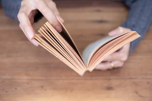 Ruka držící knihu doma — Stock fotografie