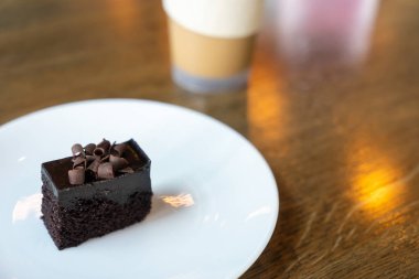 Kafede ahşap masada çikolatalı kek