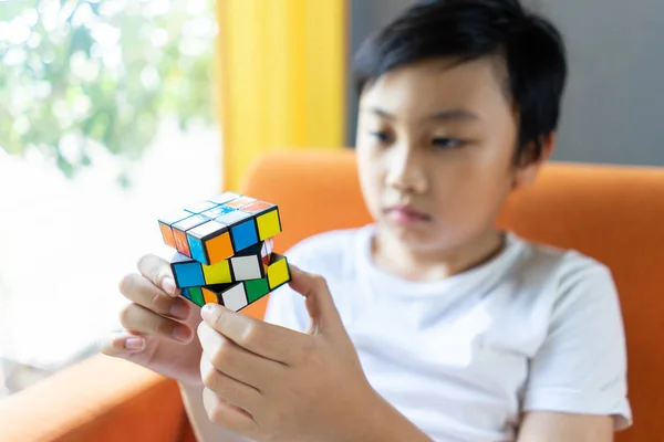 Bangkok, Thailand - 1 Oktober 2019: Anak kecil bermain Rubik 's Cub Stok Foto