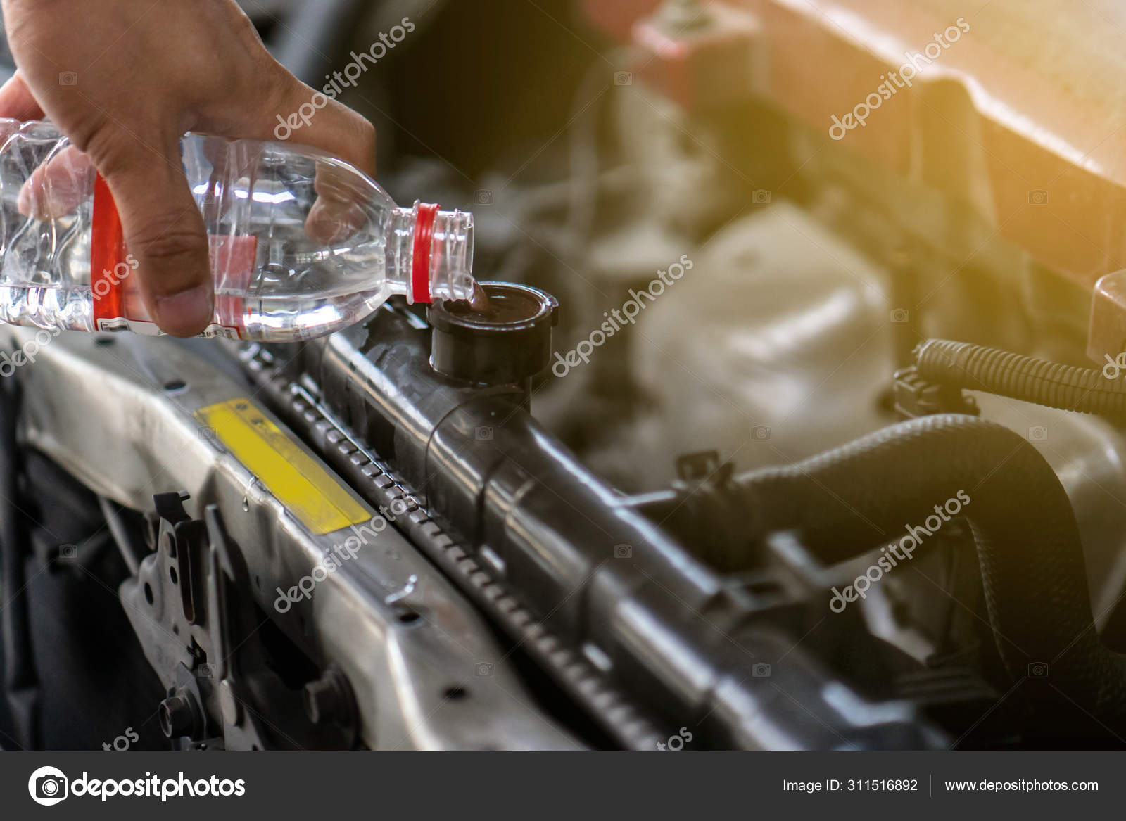 Hand pouring water for radiator in car. Because of the heat Stock Photo
