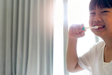 Küçük çocuk dişlerini fırçalıyor.