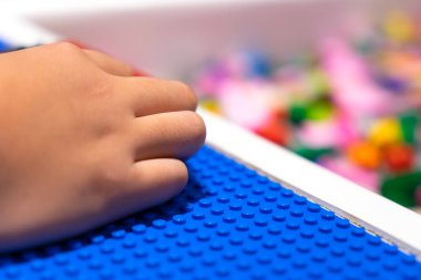 El çocuk rahatlamak için tuğla oyuncağı oynuyor.