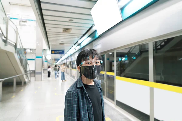 小さな男の子は公共交通機関で旅行するための顔の盾と健康マスクを身に着けています — ストック写真