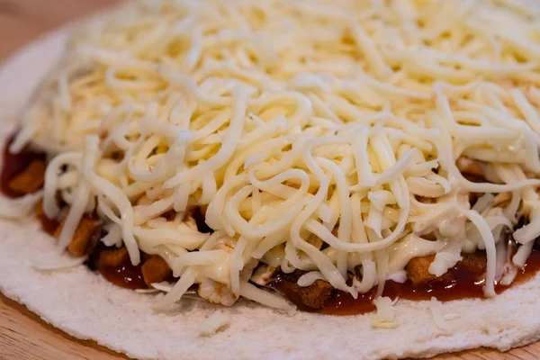 Masadaki ahşap tabakta pizza ve peynir