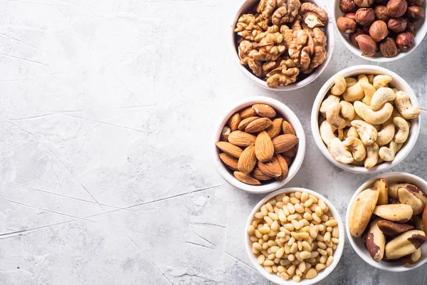 Nuts assortments on stone table top view. — Stock Photo, Image