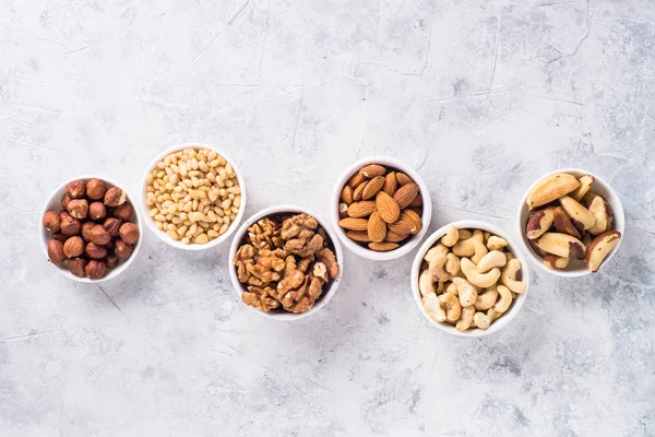 Nuts assortments on stone table top view. — Stock Photo, Image