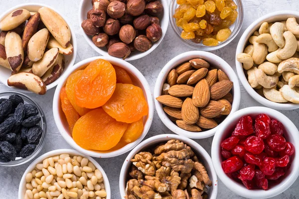 Nuts and dried fruits assortment on stone table top view. — Stock Photo, Image