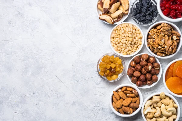 Nuts and dried fruits assortment on stone table top view. — Stock Photo, Image