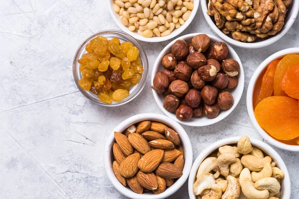 Surtido de frutos secos y frutos secos en tabla de piedra vista superior . — Foto de Stock