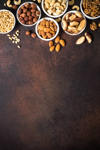 Nuts assortments on stone table top view. — Stock Photo, Image