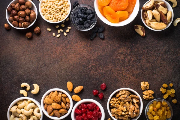 Nuts and dried fruits assortment on stone table top view. — Stock Photo, Image