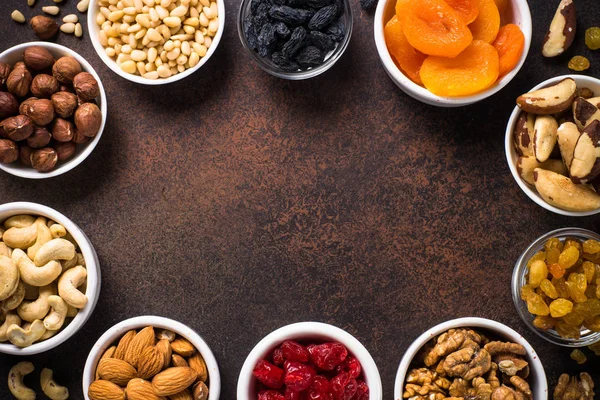 Nuts and dried fruits assortment on stone table top view. — Stock Photo, Image