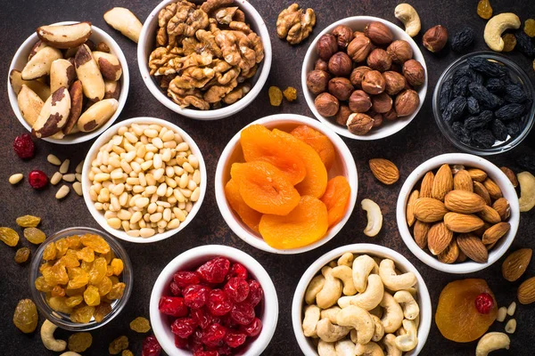 Nuts and dried fruits assortment on stone table top view. — Stock Photo, Image