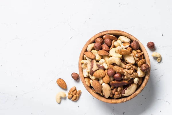 Nuts assortment in a bowl on white top view. — Stock Photo, Image
