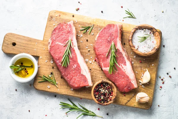 Raw beef striploin steak on cutting board. — Stock Photo, Image