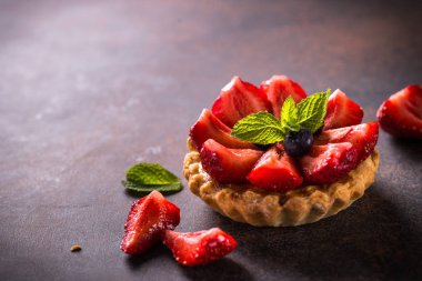 Karanlık masada Çilekli tart.