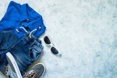 Çocuk giyim - kot pantolon, polo ve spor ayakkabı üstten görünüm.