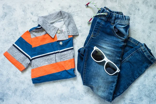 Dětské oblečení - džíny, polo a sluneční brýle, pohled shora. — Stock fotografie
