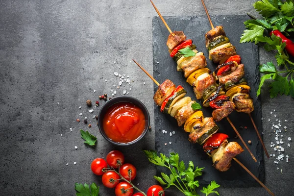 Shish kebab alla griglia con verdure su nero . — Foto Stock