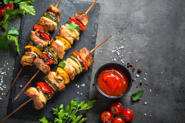 Shish kebab alla griglia con verdure su nero . — Foto Stock