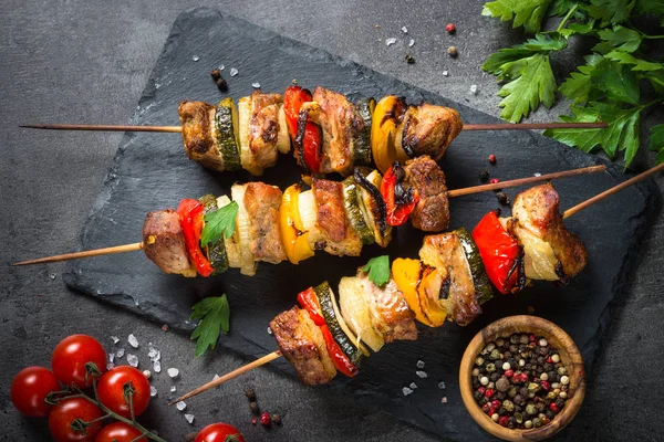 Shish kebab alla griglia con verdure su nero . — Foto Stock