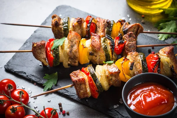 Shish kebab alla griglia con verdure su nero . — Foto Stock