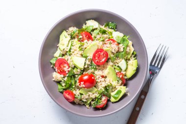 Quinoa salata ıspanak, avokado ve domates ile üst görünümü.