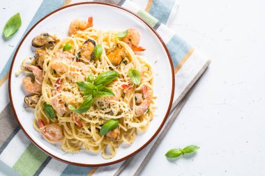 Makarna spagetti deniz ürünleri ve beyaz üzerine krema sos ile.